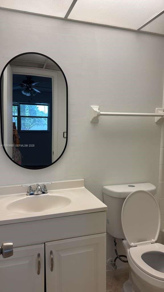 8060 North Colony Circle, Unit 207 Tamarac, FL 33321 - Photo 7 of 14 a bathroom with a toilet a sink and mirror