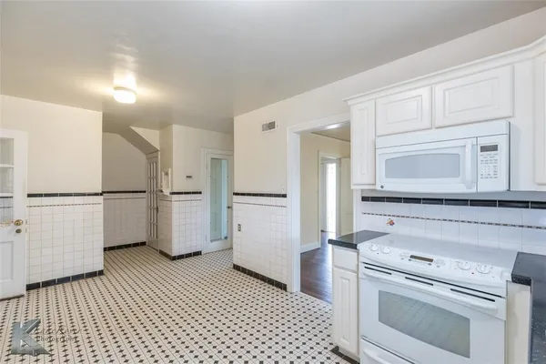 a kitchen with a refrigerator sink and cabinets