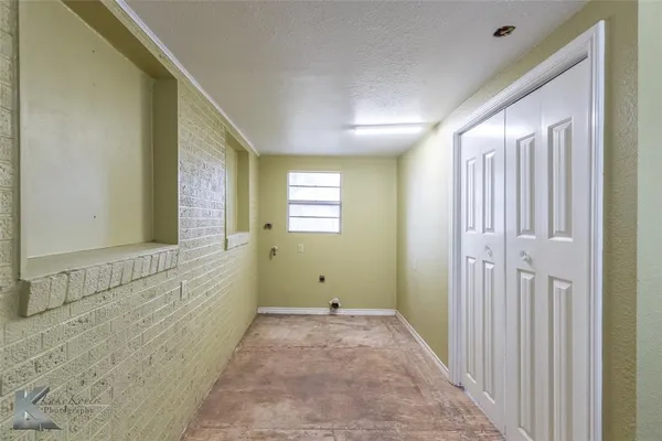 a view of a hallway with wooden floor and windows