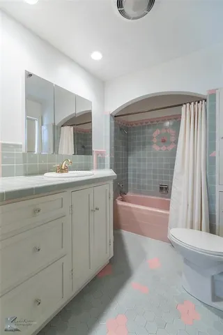 a bathroom with a granite countertop sink toilet and bathtub