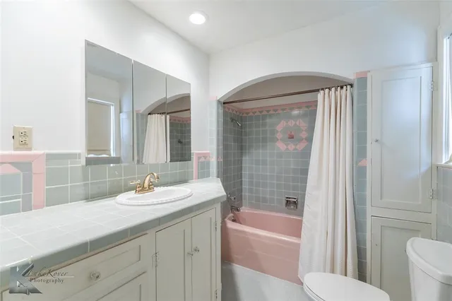 a bathroom with a sink a toilet a mirror and bathtub