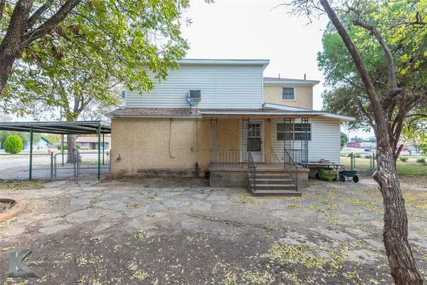 a view of a house with a backyard and a tree