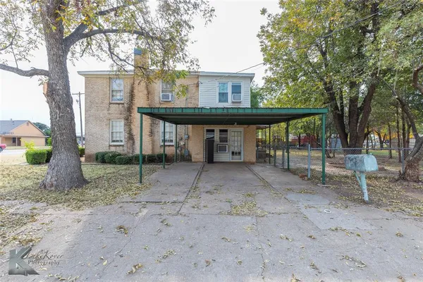 a view of a house with a backyard and a tree