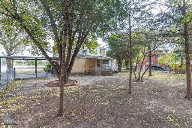 a tree in front of a white house