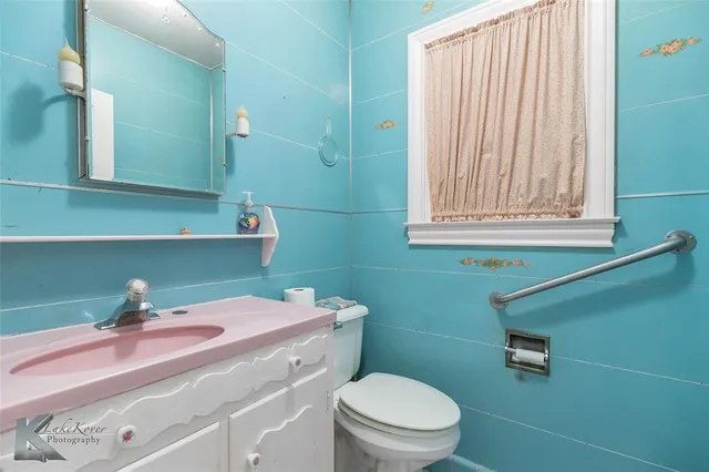 a bathroom with a sink a toilet and mirror