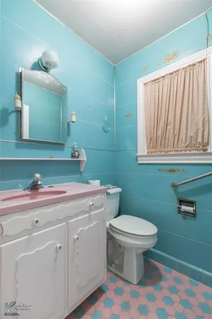 a bathroom with a sink a toilet and mirror