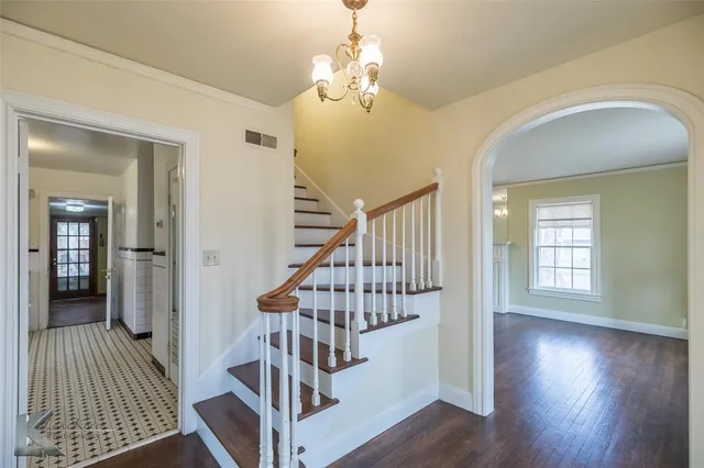 wooden floor in an entryway with a chandelier and wooden floor