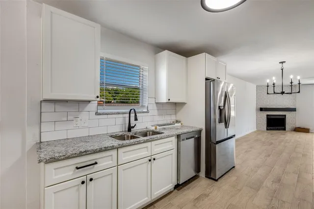 a kitchen with stainless steel appliances granite countertop a refrigerator sink and cabinets