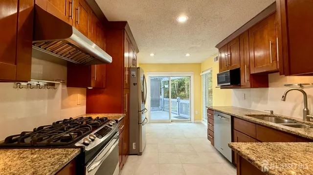 a kitchen with granite countertop stove and cabinets