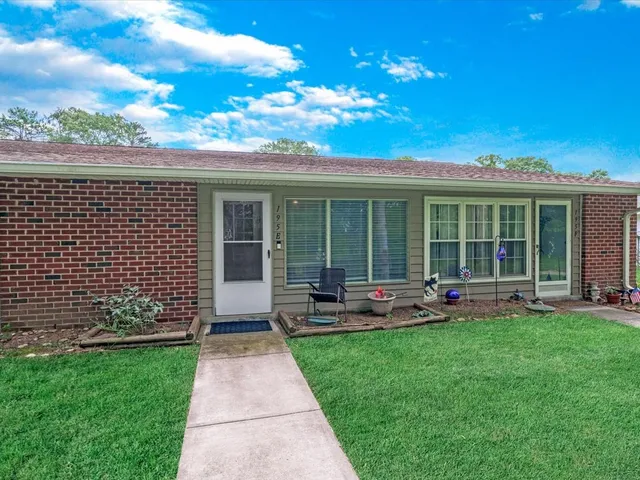 a front view of a house with a garden and patio