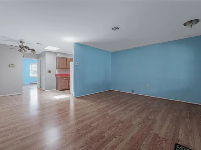 a view of empty room with wooden floor