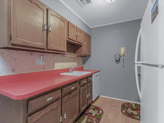 a kitchen with a sink a refrigerator and cabinets