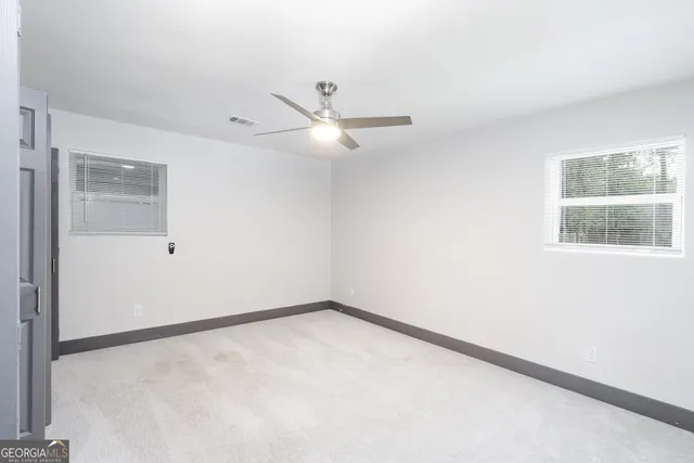 an empty room with closet and a ceiling fan