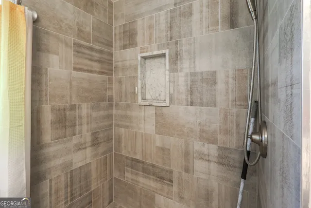 a walk in closet with wooden floor