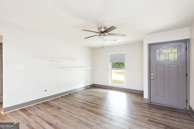 an empty room with wooden floor and window