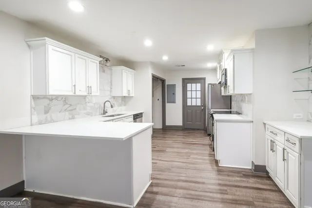 a kitchen with a sink white cabinets and white appliances