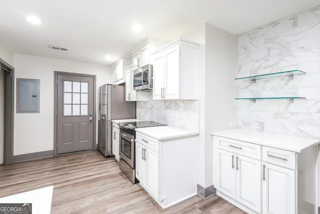 a kitchen with white cabinets and appliances
