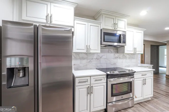 a kitchen with stainless steel appliances granite countertop a refrigerator stove and microwave
