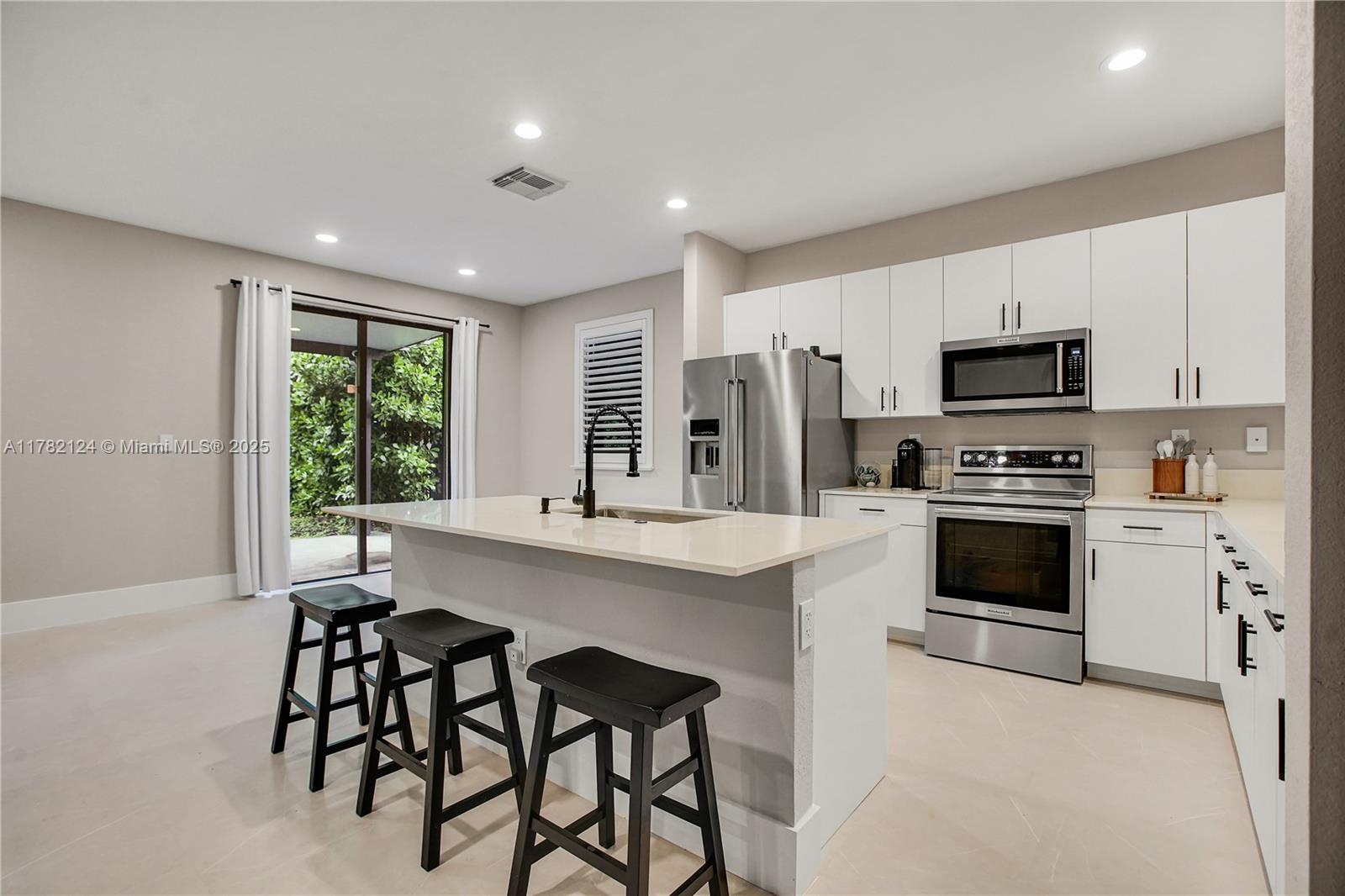15451 Southwest 173rd Lane Miami, FL 33187 - Photo 5 of 17 a kitchen with granite countertop white cabinets and stainless steel appliances
