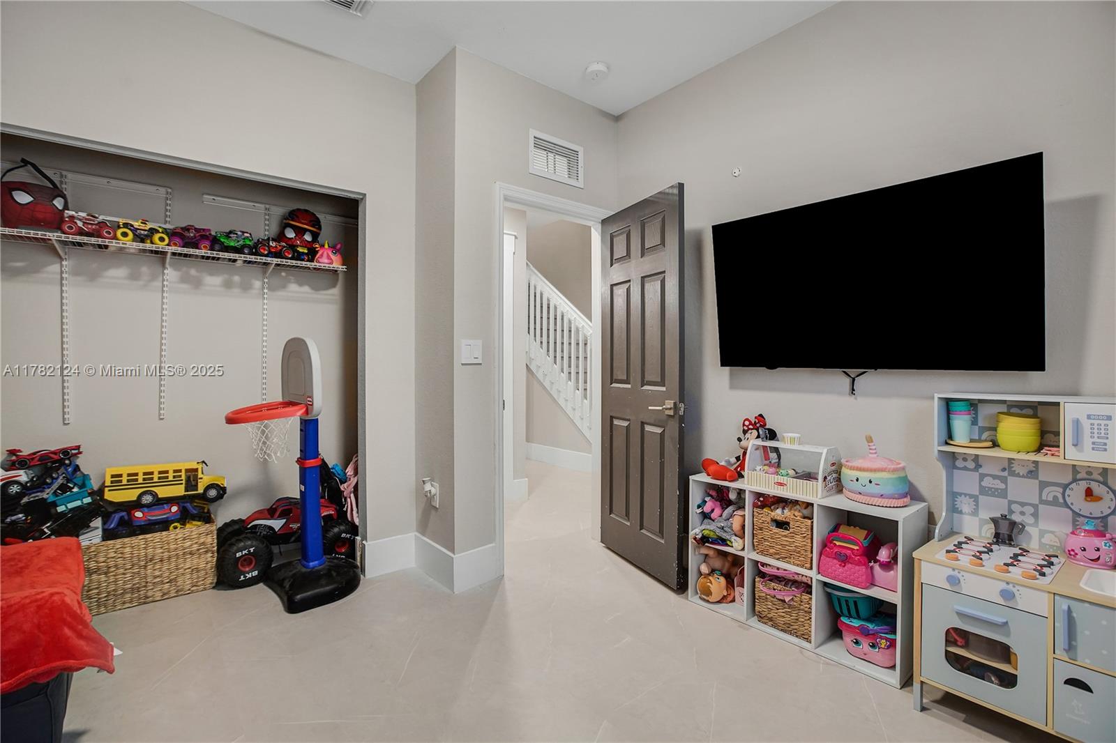15451 Southwest 173rd Lane Miami, FL 33187 - Photo 7 of 17 a children room with toys and a flat screen tv