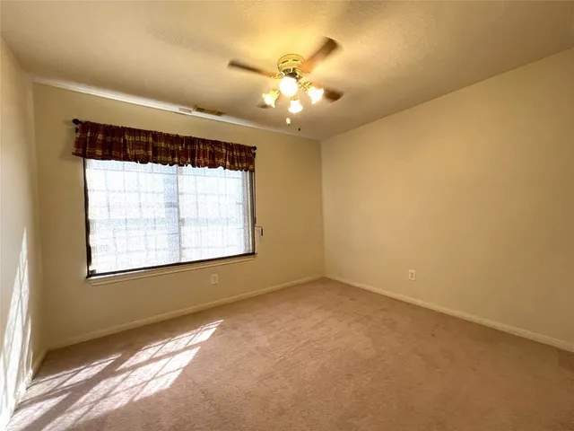 a view of a livingroom with a ceiling fan and window