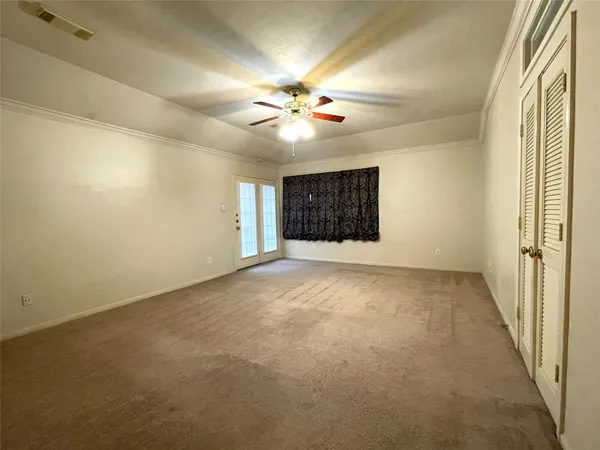 en empty room with windows and fan