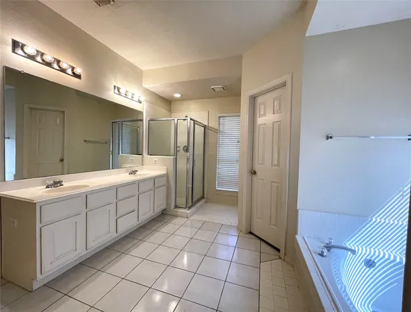 a bathroom with a double vanity sink mirror and shower
