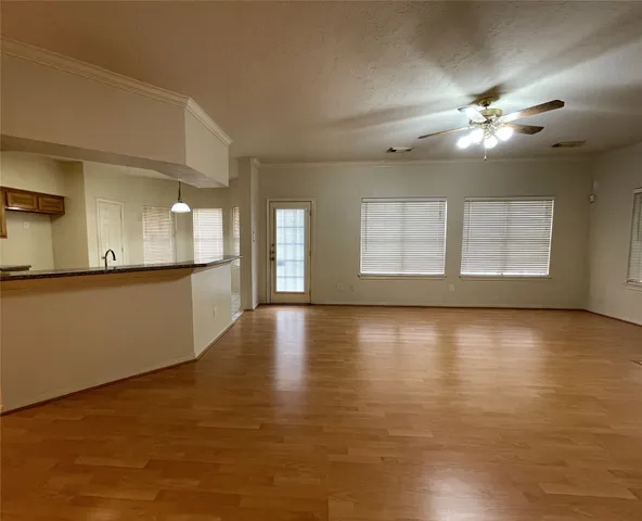 a view of an empty room with window and wooden floor