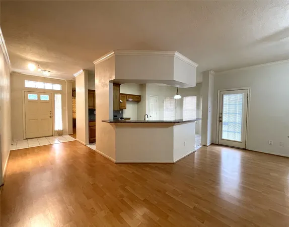 a view of a kitchen with a fridge and wooden floor