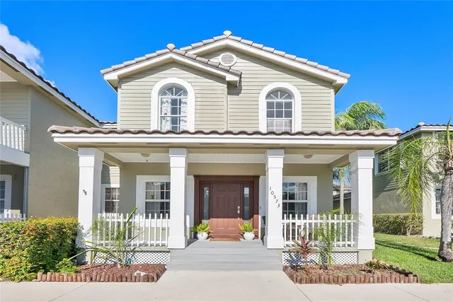a view of a white house with large windows and a small yard