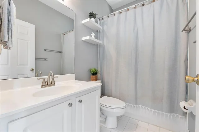 a bathroom with a sink a toilet and shower curtain