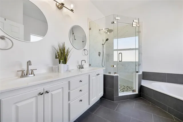 a spacious bathroom with a double vanity sink mirror and bathtub