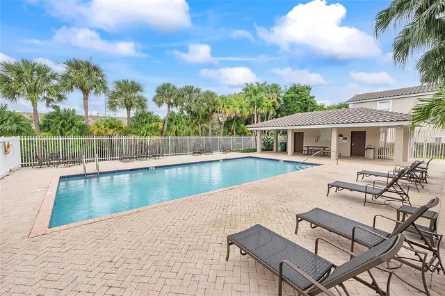 a view of a house with pool and sitting area