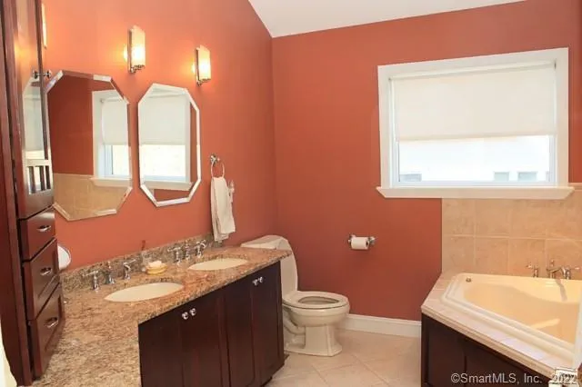 a bathroom with a sink vanity mirror and toilet