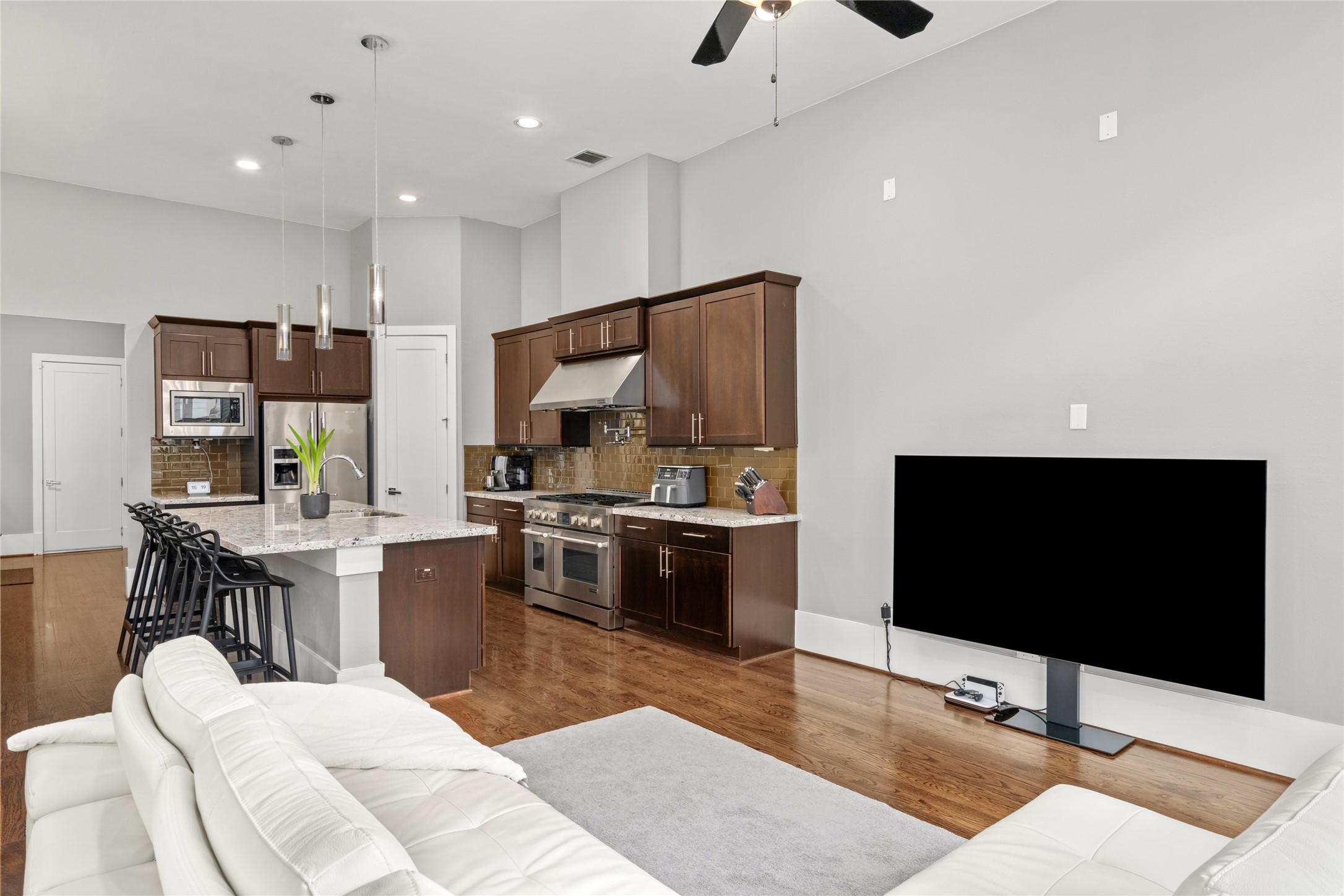 1605 Knox Street, Unit B Houston, TX 77007 - Photo 12 of 28 a living room with stainless steel appliances kitchen island granite countertop a couch and a flat screen tv