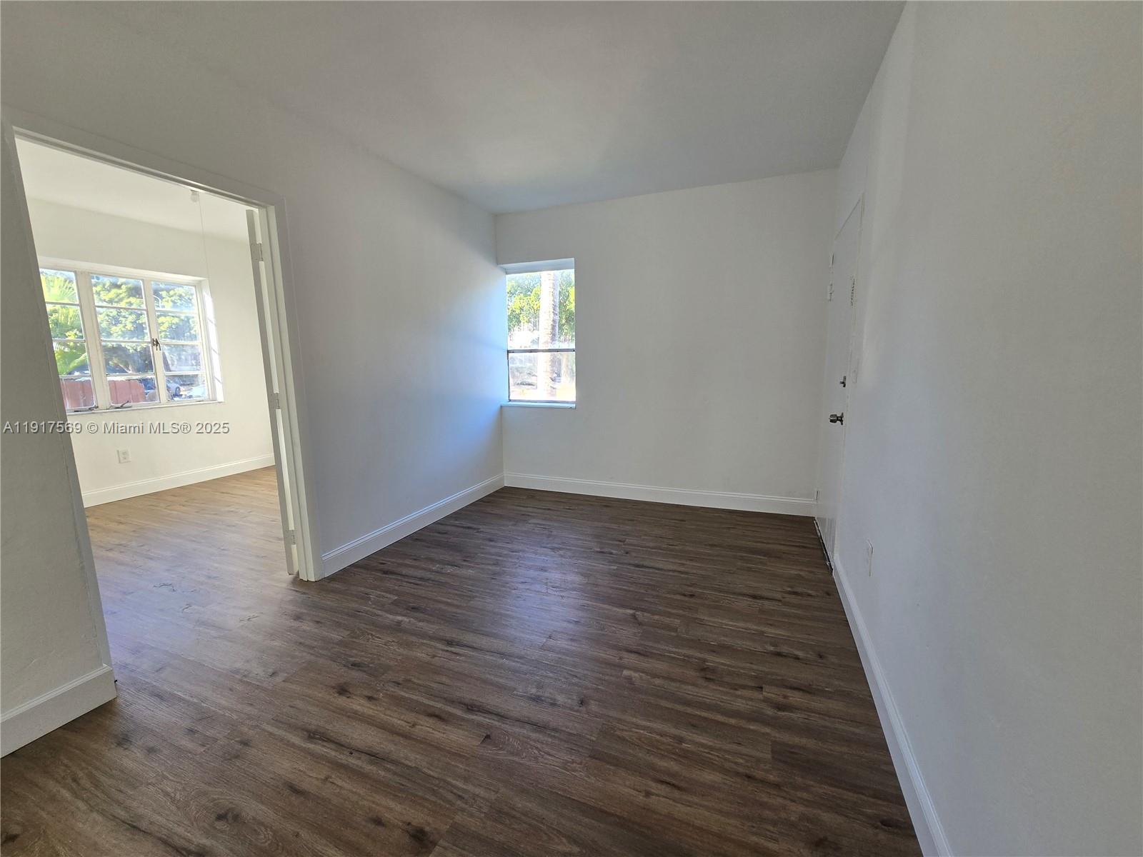 660 84th Street, Unit 39 Miami Beach, FL 33141 - Photo 5 of 17 an empty room with wooden floor and windows