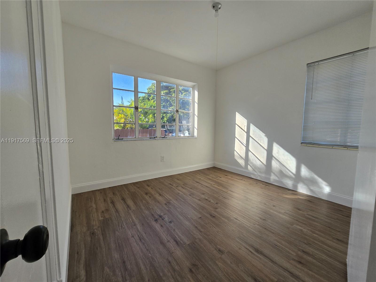 660 84th Street, Unit 39 Miami Beach, FL 33141 - Photo 6 of 17 a view of an empty room with wooden floor and a window