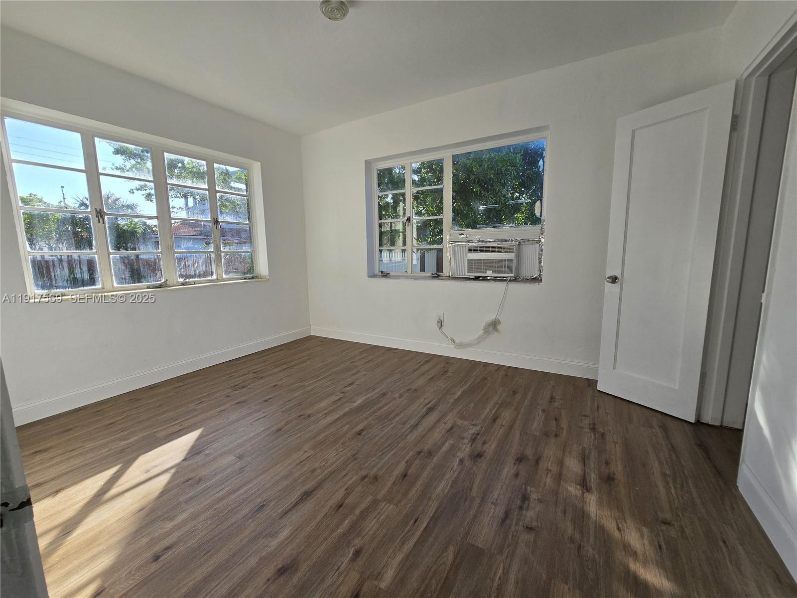 660 84th Street, Unit 39 Miami Beach, FL 33141 - Photo 10 of 17 a view of an empty room with wooden floor and a window