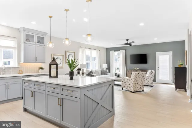 a large kitchen with kitchen island granite countertop a sink and white cabinets
