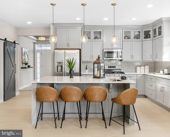 a kitchen with stainless steel appliances granite countertop a stove a sink a refrigerator a oven a microwave oven with a dining table and chairs