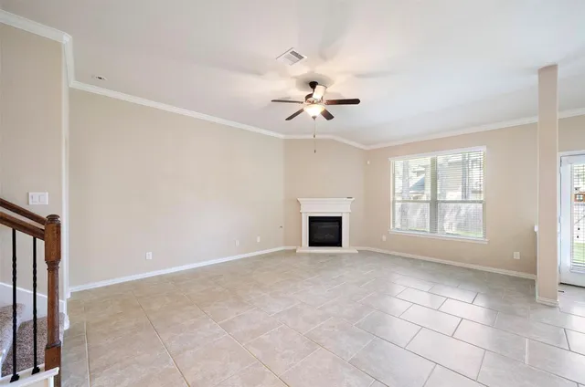 a view of an empty room with a fireplace and a window