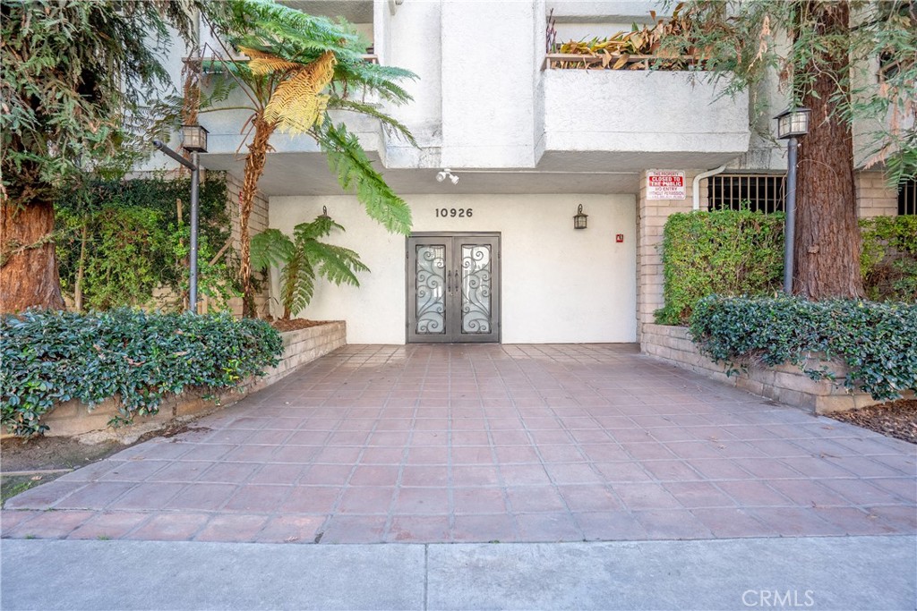 10926 Bluffside Drive, Unit 9 Studio City, CA 91604 - Photo 29 of 43 front view of a house with a yard and an trees