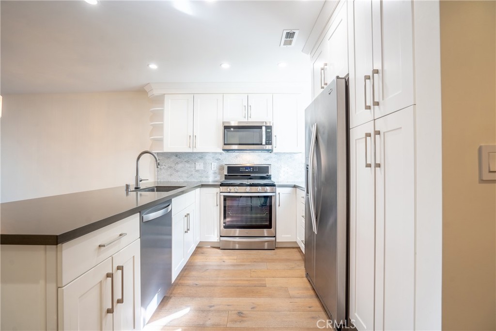 10926 Bluffside Drive, Unit 9 Studio City, CA 91604 - Photo 7 of 43 a kitchen with stainless steel appliances granite countertop a refrigerator and a stove
