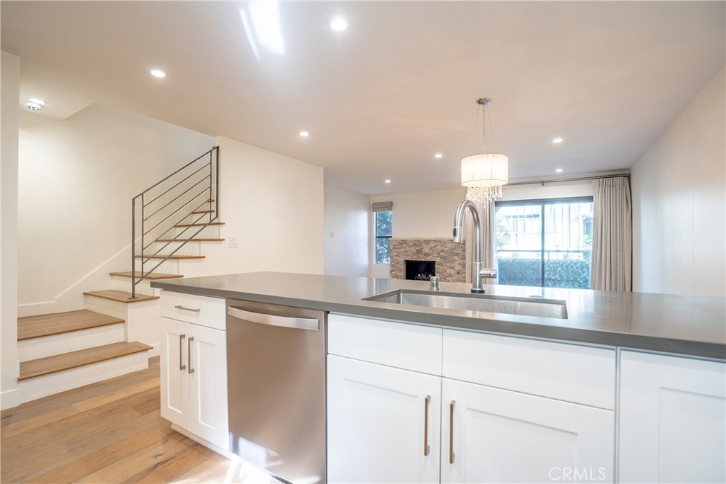 10926 Bluffside Drive, Unit 9 Studio City, CA 91604 - Photo 8 of 43 a kitchen with granite countertop kitchen island white cabinets and white appliances