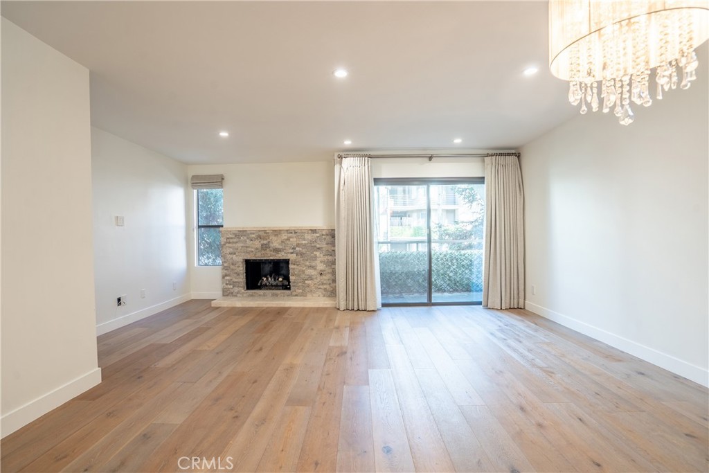 10926 Bluffside Drive, Unit 9 Studio City, CA 91604 - Photo 9 of 43 an empty room with wooden floor fireplace and windows