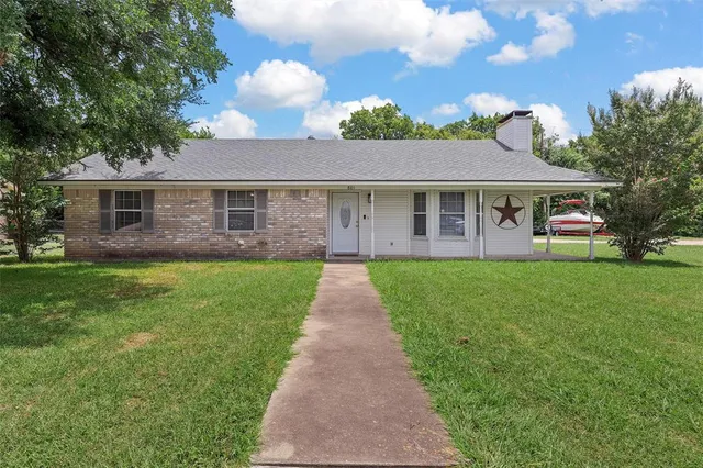 a front view of house with yard and green space