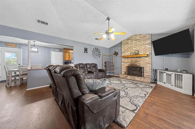 a living room with furniture a flat screen tv and a fireplace