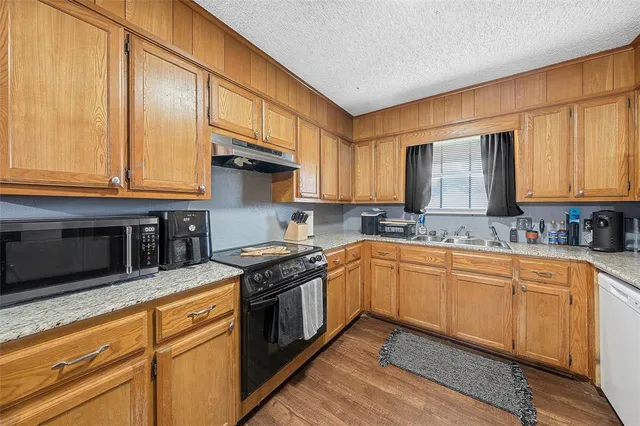 a kitchen with stainless steel appliances granite countertop a stove a sink and a microwave