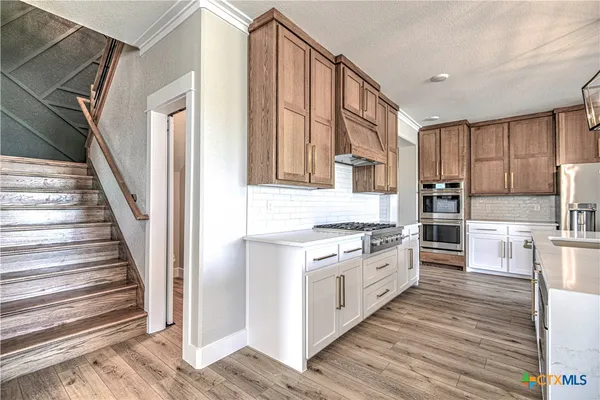 a kitchen with stainless steel appliances granite countertop a stove and a refrigerator