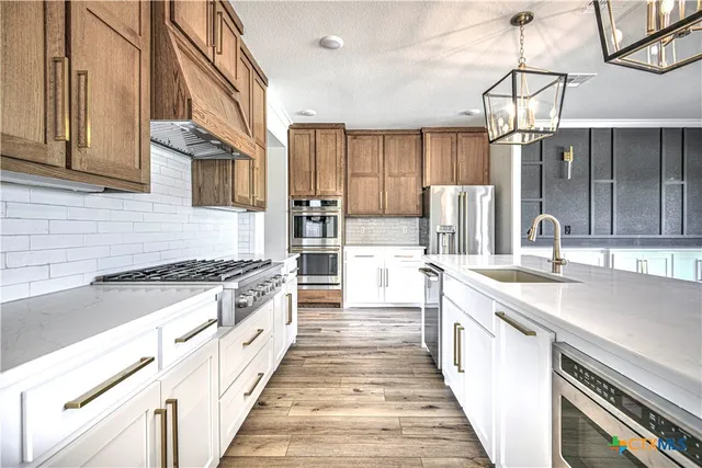 a kitchen with stainless steel appliances granite countertop a stove and a sink